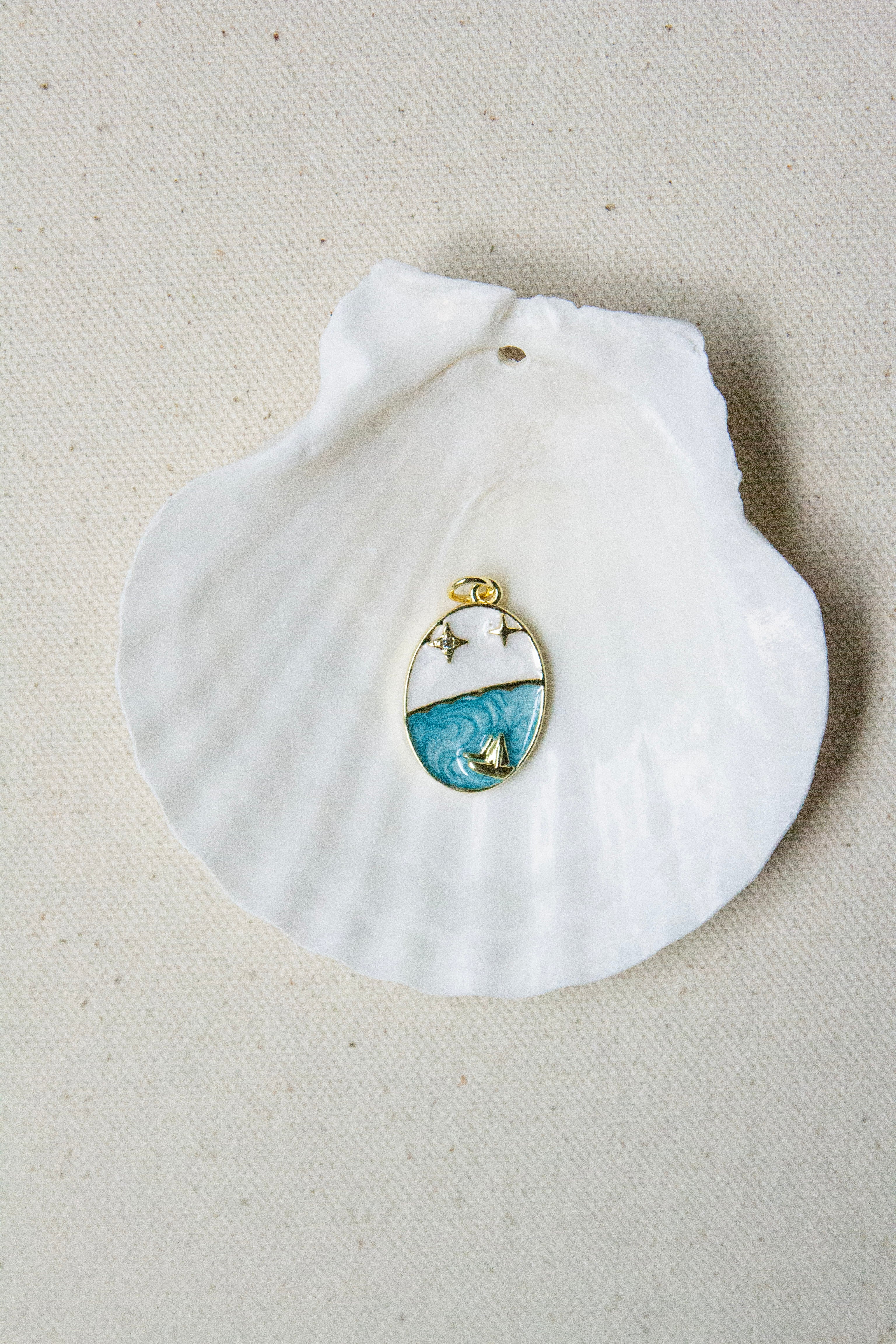 Oval blue & white sailboat charm