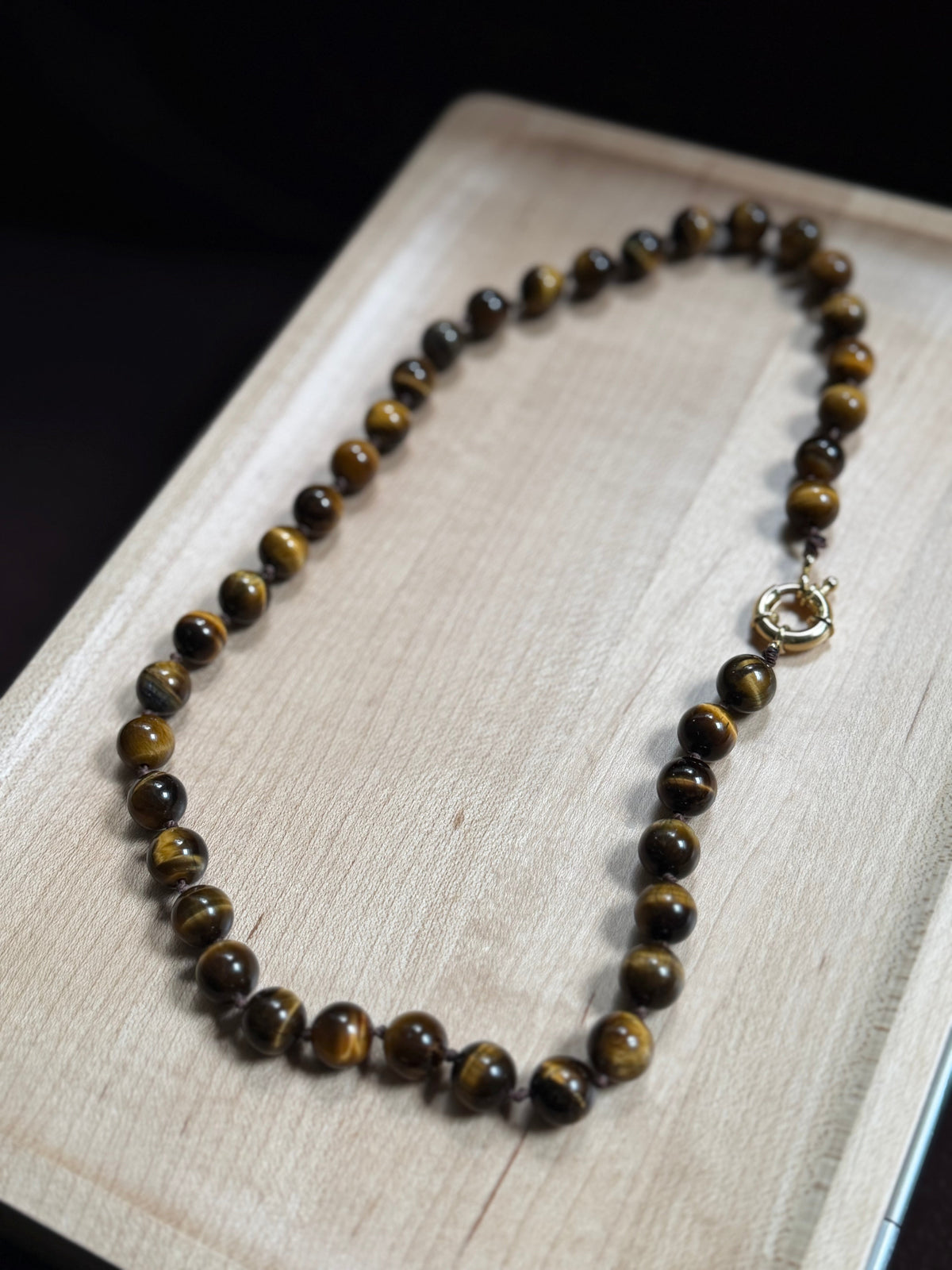 Tiger Eye Knotted Necklace laid flat on wood surface